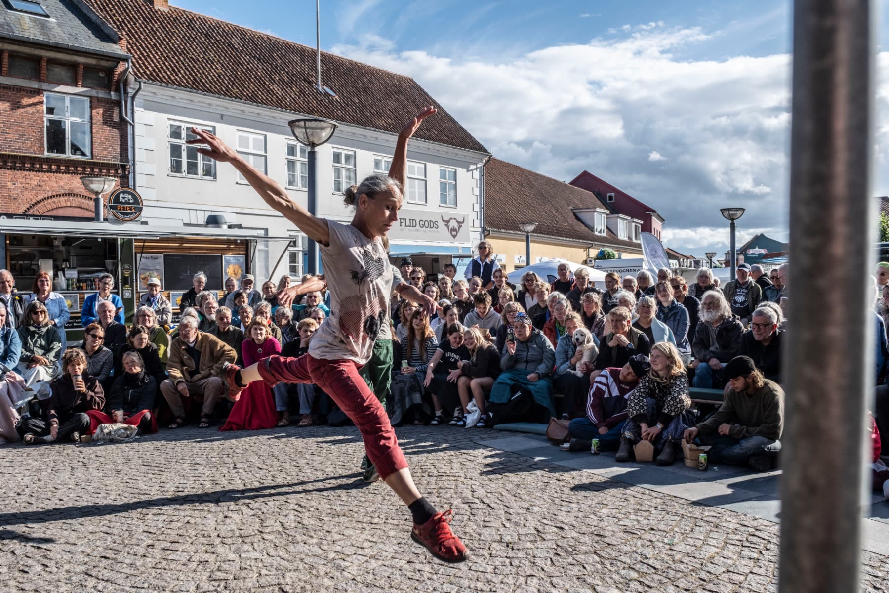 Danser optræder på et torv foran et stort publikum